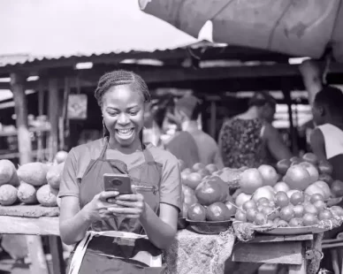 excited-african-market-woman-using-mobile-phone-1-768x512
