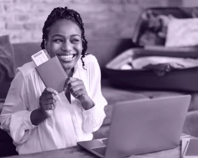 excited-black-woman-with-passport-tickets-using-laptop-buy-tourist-vacation-e1738075218874