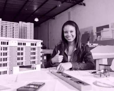 smiling-african-american-woman-showing-thumb-up-near-model-building_23-2148039858